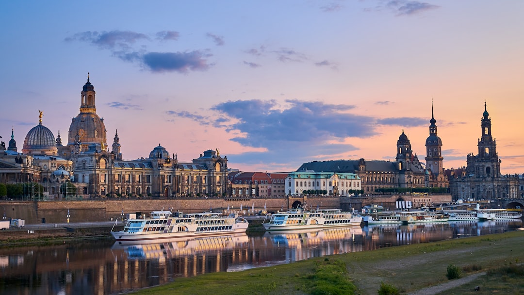 Dresdner Altstadt-Panorama mit Frauenkirche und Kathedrale an der Elbe während der Abenddämmerung mit Ausflugsschiffen