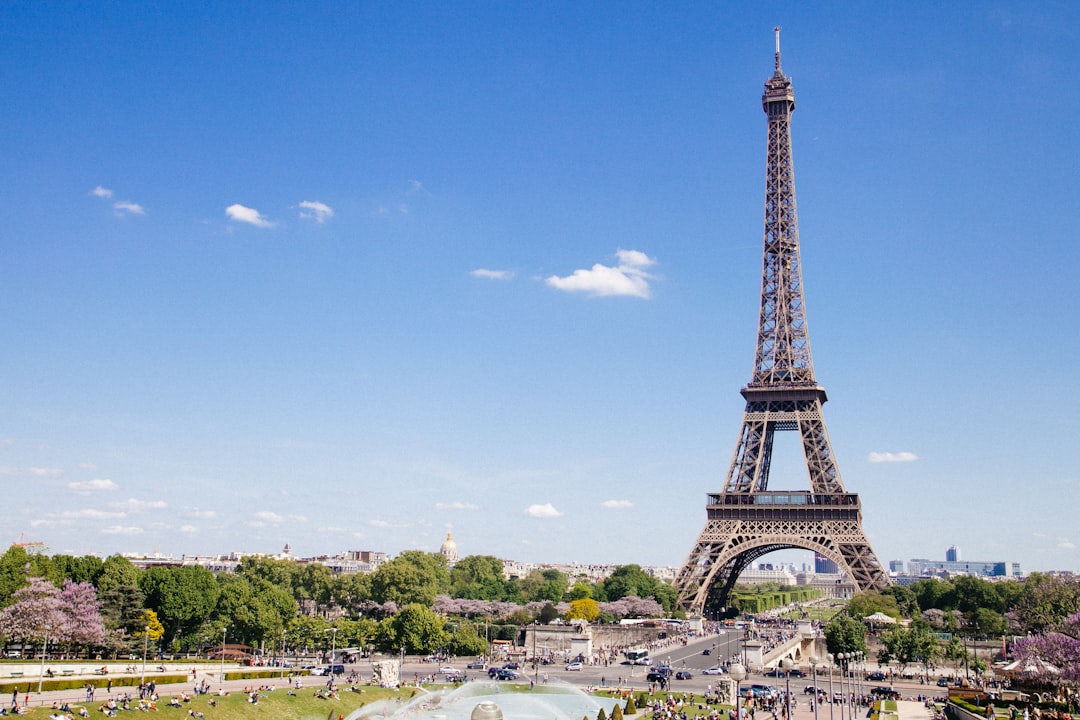 Der Eiffelturm in Paris unter strahlend blauem Himmel, gesehen vom Trocadéro mit Blick über die Seine und Grünanlagen