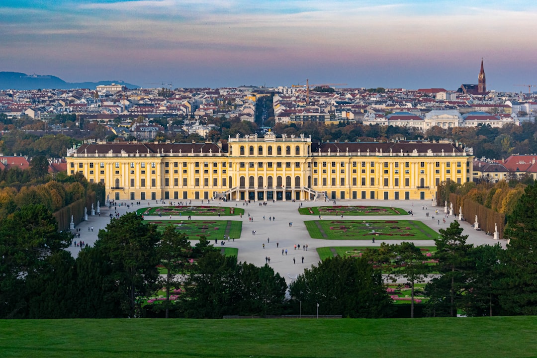 Panorama-Blick auf Schloss Schönbrunn in Wien mit den barocken Gartenanlagen vor der herbstlichen Stadtkulisse bei Dämmerung
