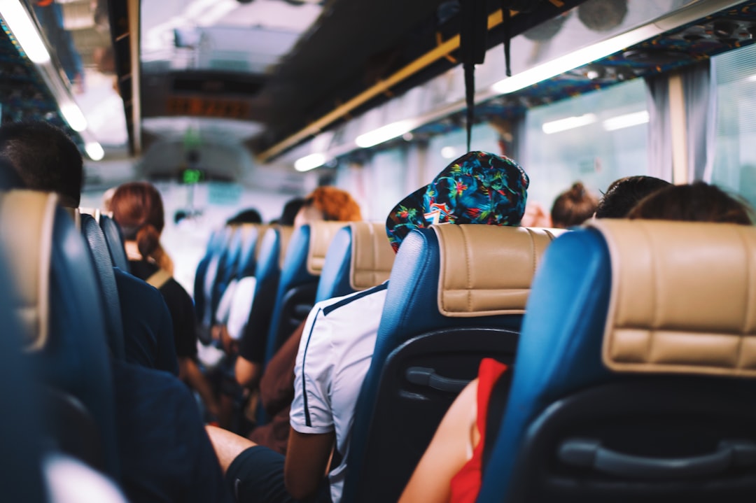 Blick durch den Mittelgang eines voll besetzten Reisebusses mit Passagieren in ihren Sitzen während der Fahrt